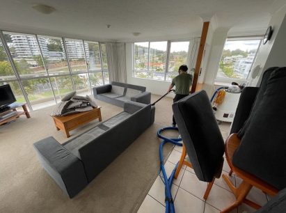 Man Vacuuming Living Room Carpet — Professional Carpet Cleaners in Gold Coast, QLD