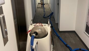 Man Vacuuming Hallway — Professional Carpet Cleaners in Gold Coast, QLD