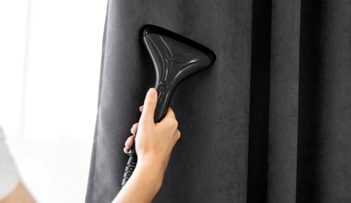 Vacuuming The Curtains — Professional Carpet Cleaners in Gold Coast, QLD